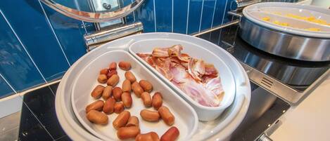 A buffet setup with two sections: one with sliced bacon and the other with peanuts.