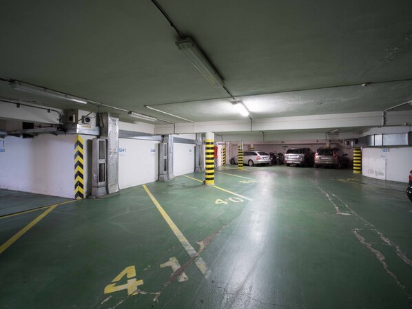 A multi-level parking garage with clearly marked parking spaces and directional arrows on the floor. - Hotel Beranek Prague (Prague)