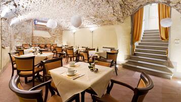 Un restaurante con paredes de piedra, mesas y sillas de madera.