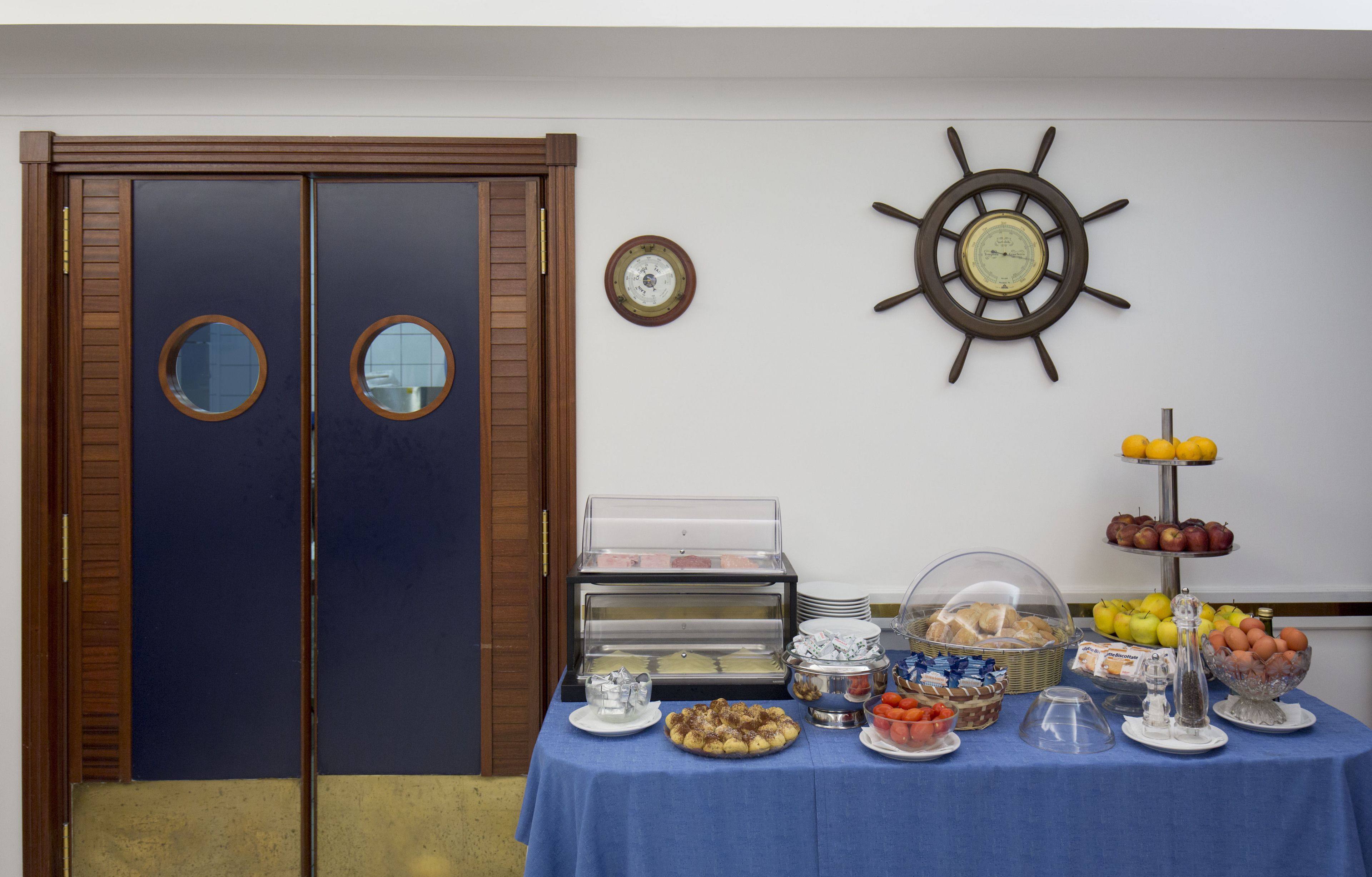A buffet table with various food items and a clock on the wall.