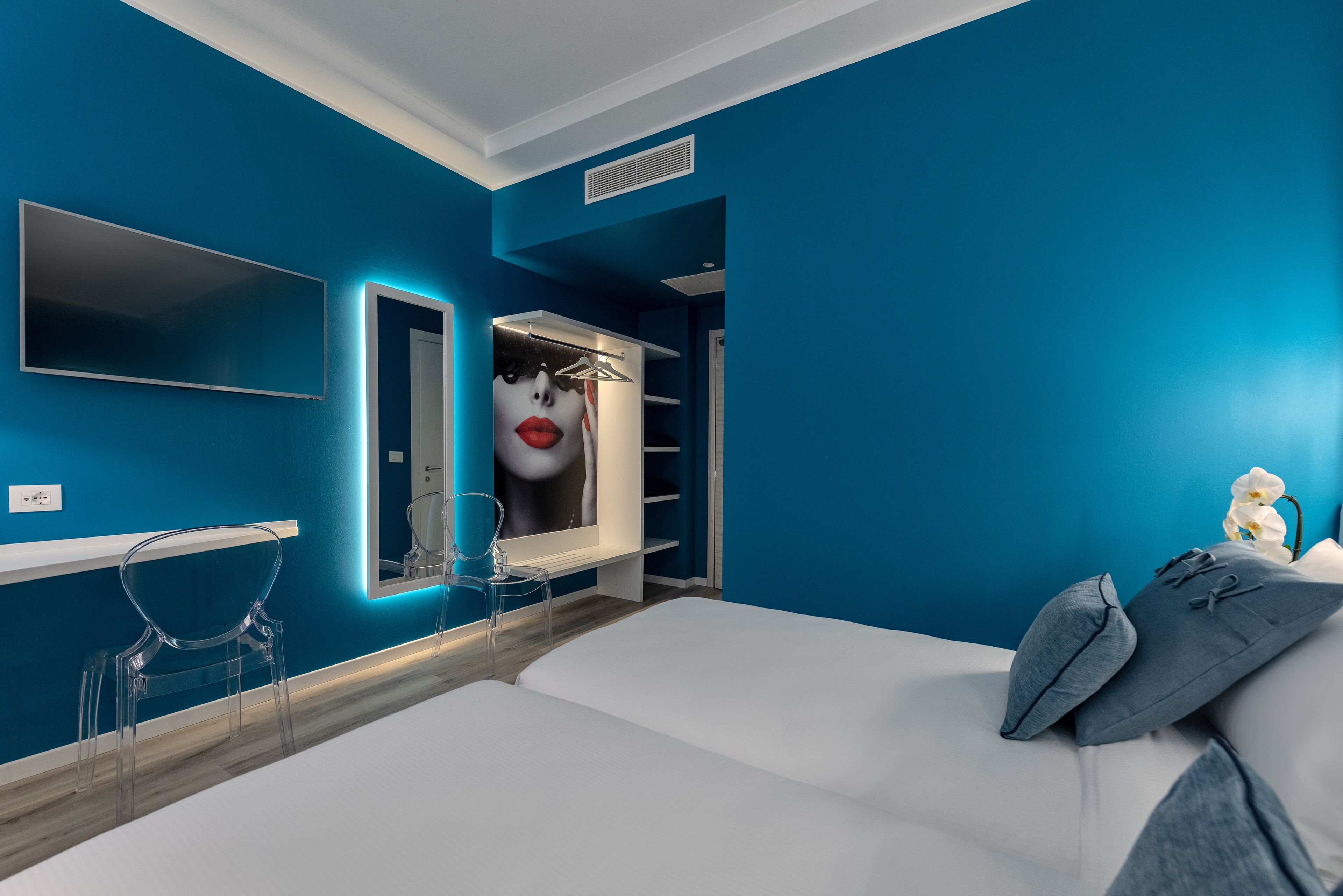 Ein modernes Schlafzimmer mit einem großen Bett, einem Nachttisch, einem Spiegel und einem Kleiderschrank.