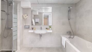 A modern bathroom with a glass-enclosed shower, a white sink, and a bathtub.