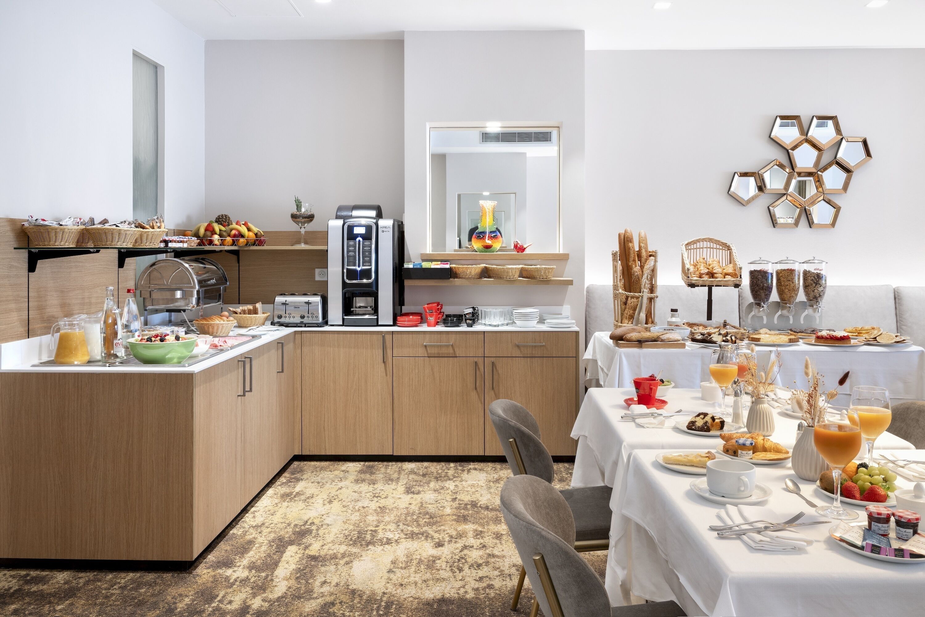 A modern breakfast setup with a coffee machine, fruit bowl, and breakfast items on a counter.