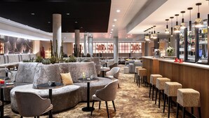 Ein stilvoller Lounge-Bereich mit Sofas, Tischen und Barhocker.