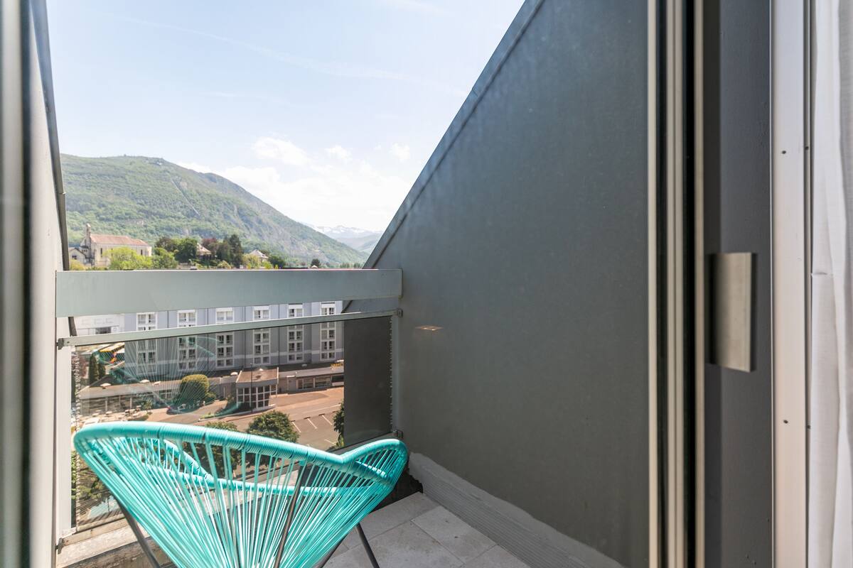 A balcony with a view of a mountain and buildings.