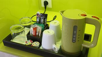 Un plateau contenant une machine à café, une tasse, un bocal en verre et quelques aliments emballés.