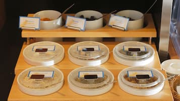 A buffet with labeled containers of various food items.