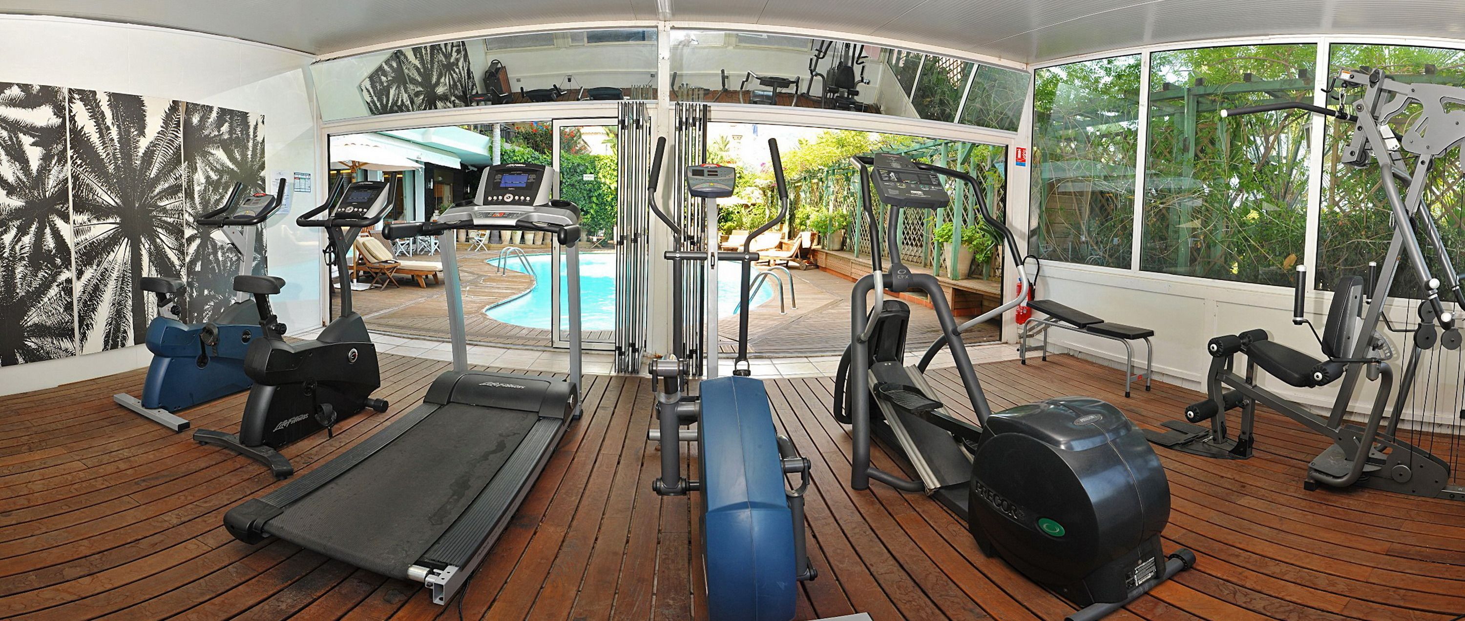 A fitness area with treadmills, elliptical machines, and weight equipment.