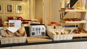 A breakfast buffet with bread, pastries, and a toaster. - Hotel Napoleon (Menton)