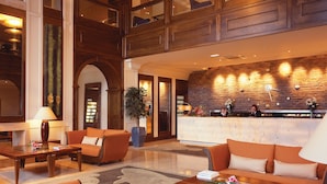 A spacious lobby with a high ceiling, a reception desk, and seating areas. - The Brehon Hotel & Spa (Killarney)