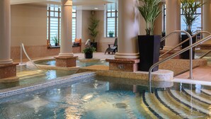 An indoor swimming pool with tiled steps, columns, and potted plants. - The Brehon Hotel & Spa (Killarney)
