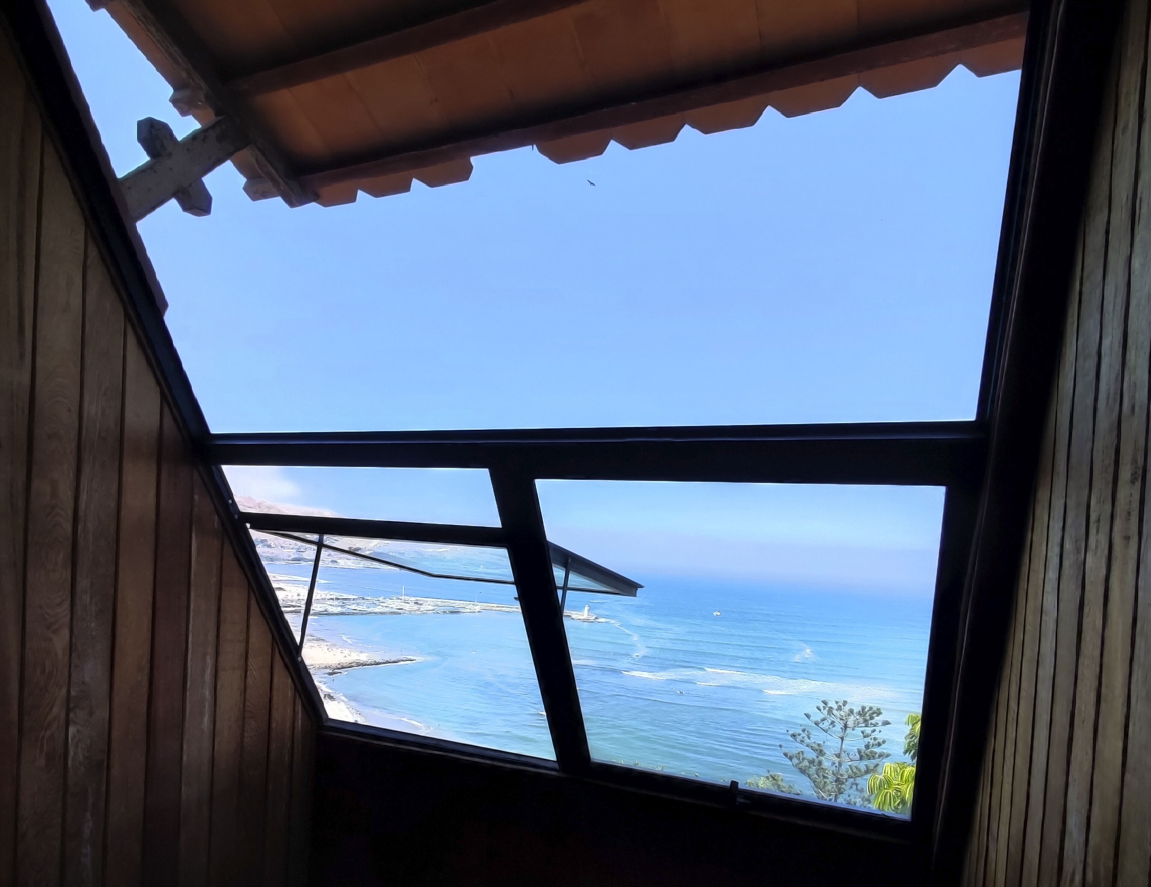 Una habitación con un tragaluz grande que ofrece vistas al mar.