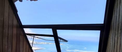 Una habitación con un tragaluz grande que ofrece vistas al mar.