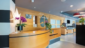 A hotel reception desk with a wooden finish, a large sign reading 'HOTEL LOREAK,' and a modern interior design. - Hôtel Loreak (Bayonne)