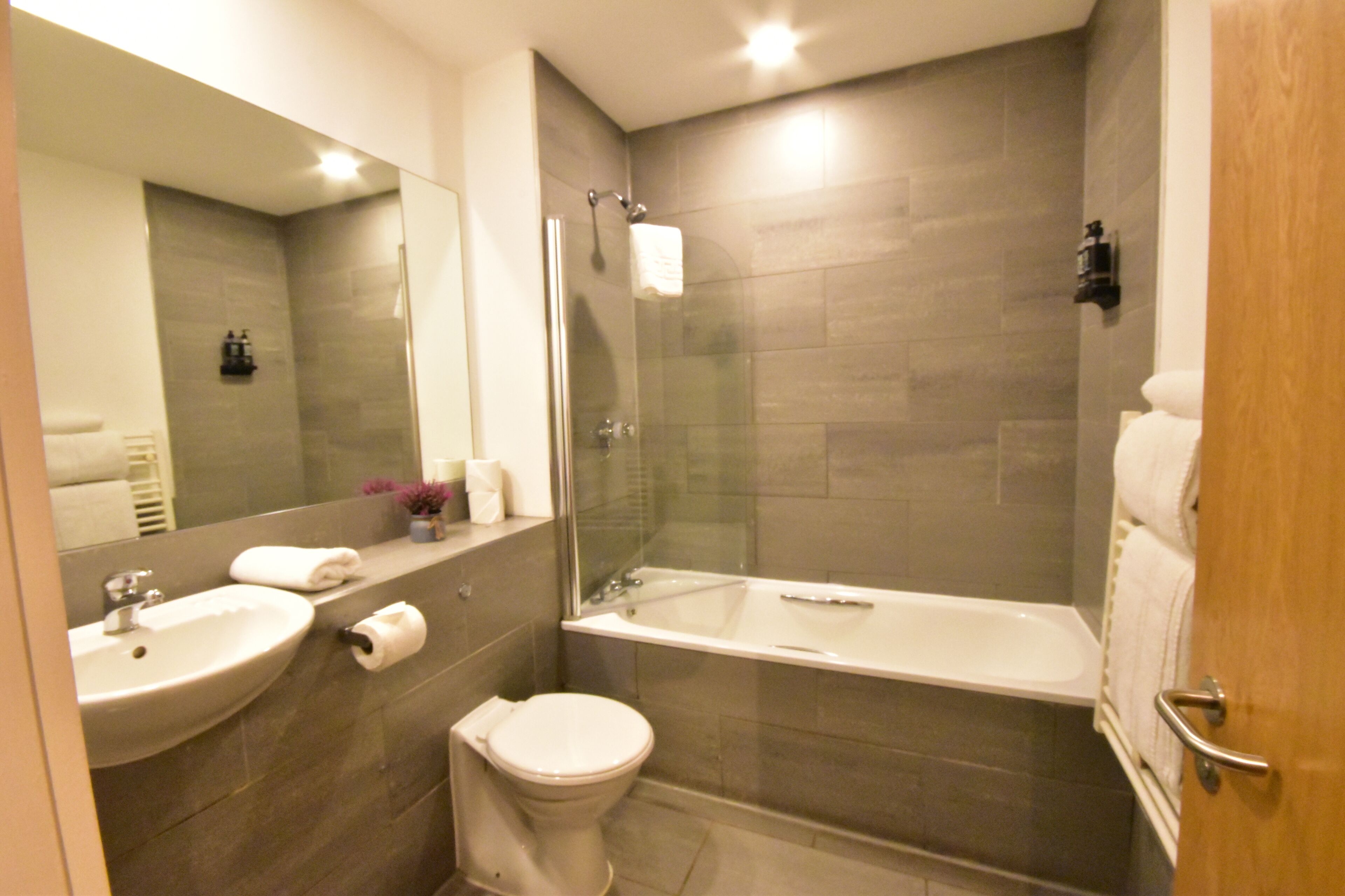 Un baño moderno con lavabo, inodoro y bañera.