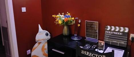 A room with a director's chair, a clapperboard, and a Star Wars droid.
