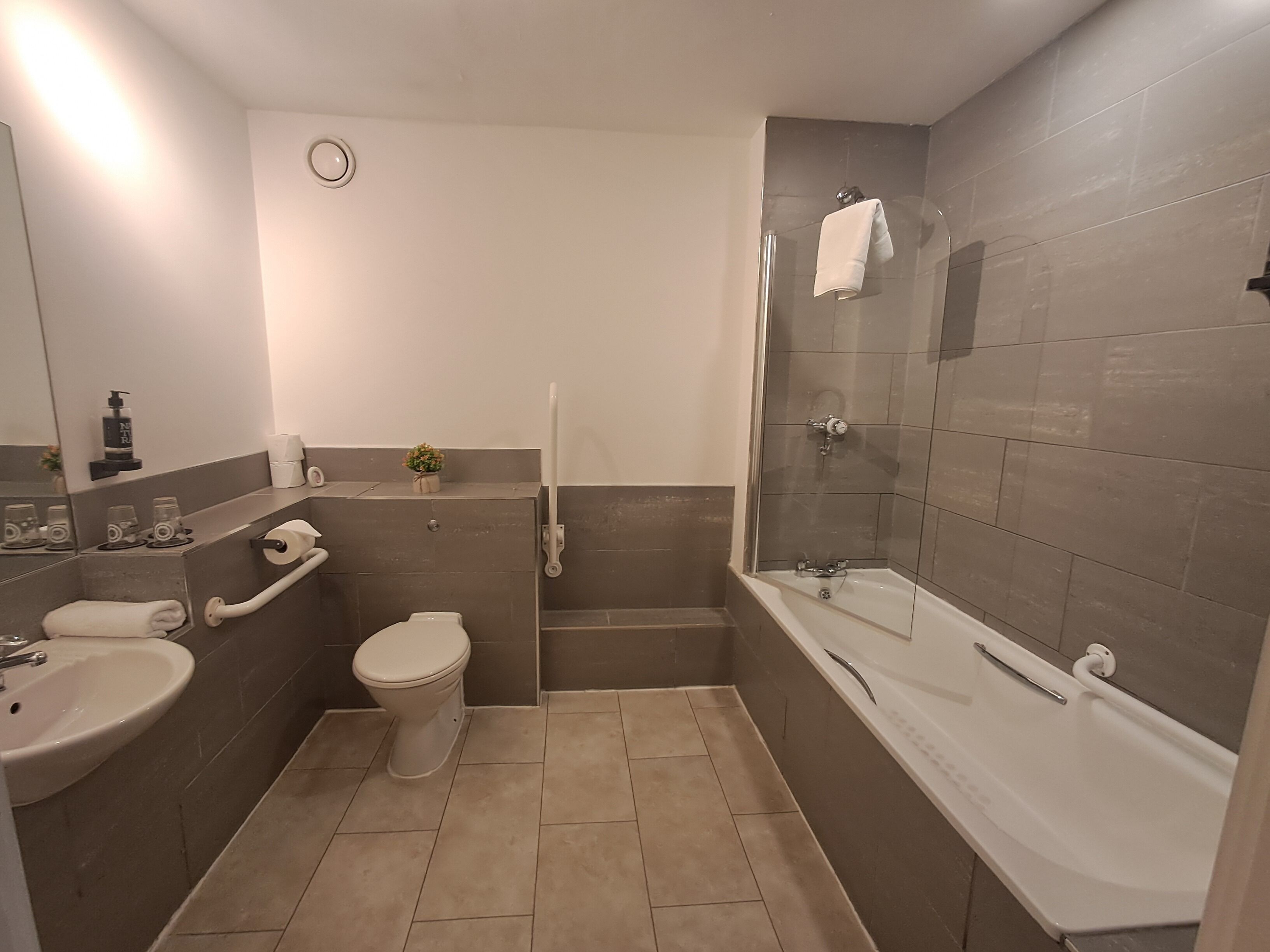 A modern bathroom with a toilet, sink, and bathtub.