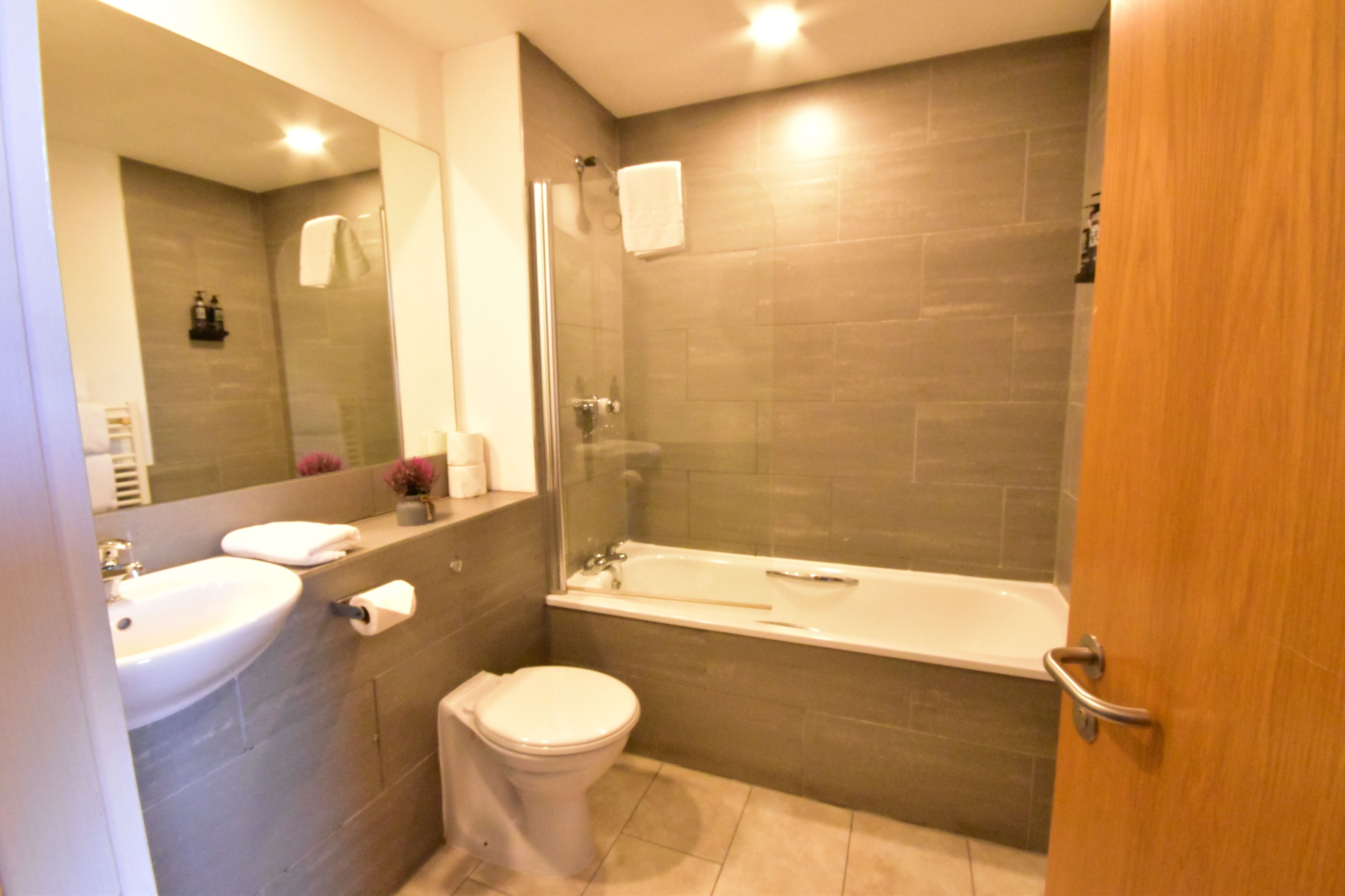 Een badkamer met een wastafel, toilet en bad.