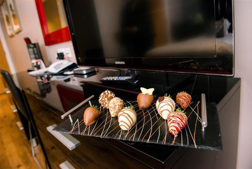 Una cocina equipada con microondas, cafetera y televisor.