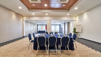 Une salle de conférence dotée d’une longue table, de chaises et d’un plafond pourvu d’un éclairage encastré.
