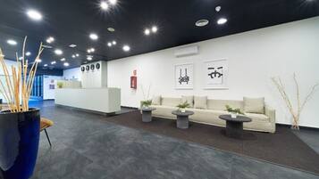 Un área de recepción moderna con mostrador, asientos y detalles decorativos.