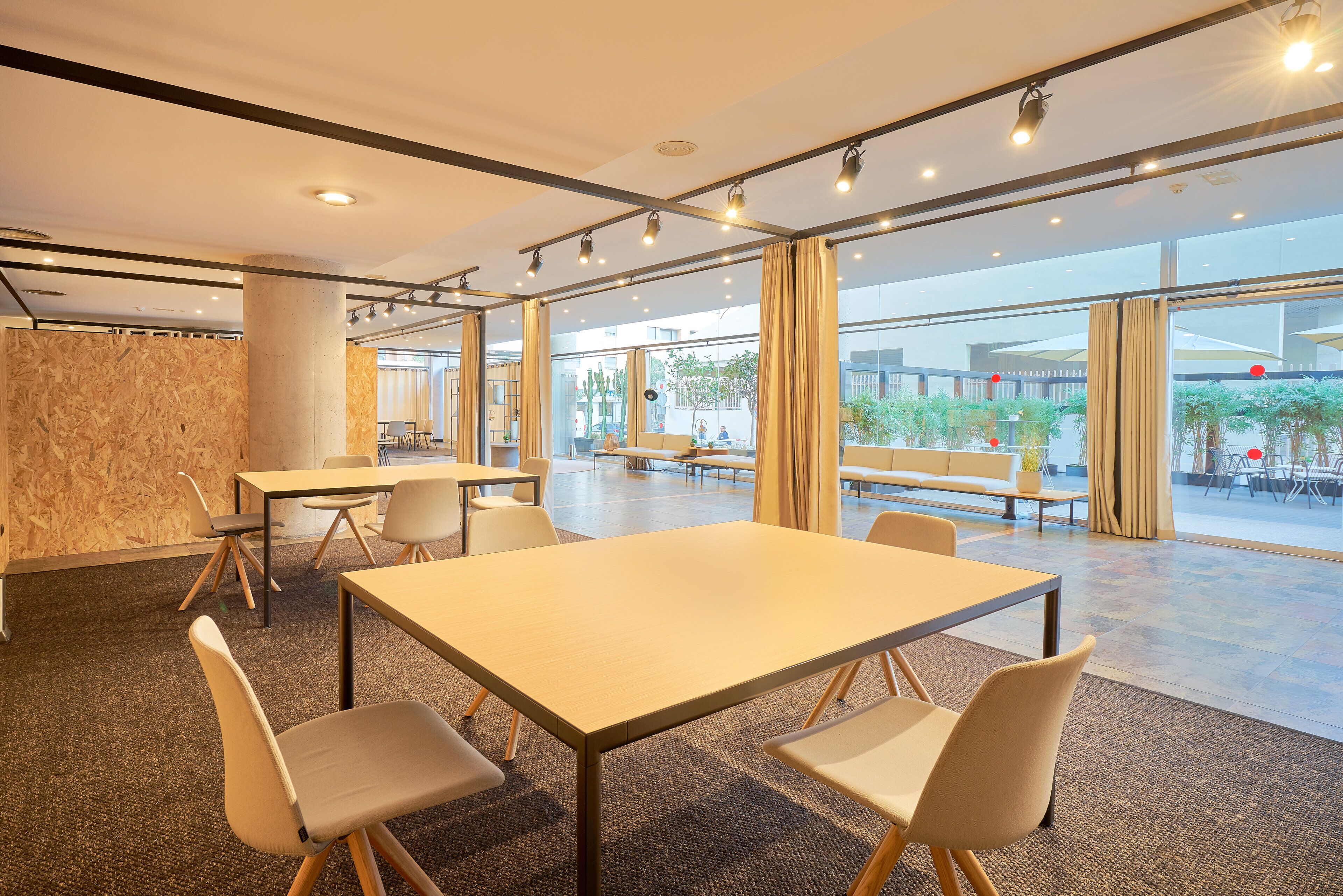 Een moderne vergaderzaal met een grote tafel, stoelen en uitzicht op het buitengebied.