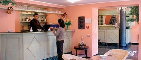 A hotel reception area with a counter, bar, and seating area.
