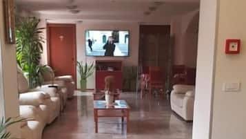 A living room with a sofa set, a coffee table, and a television.
