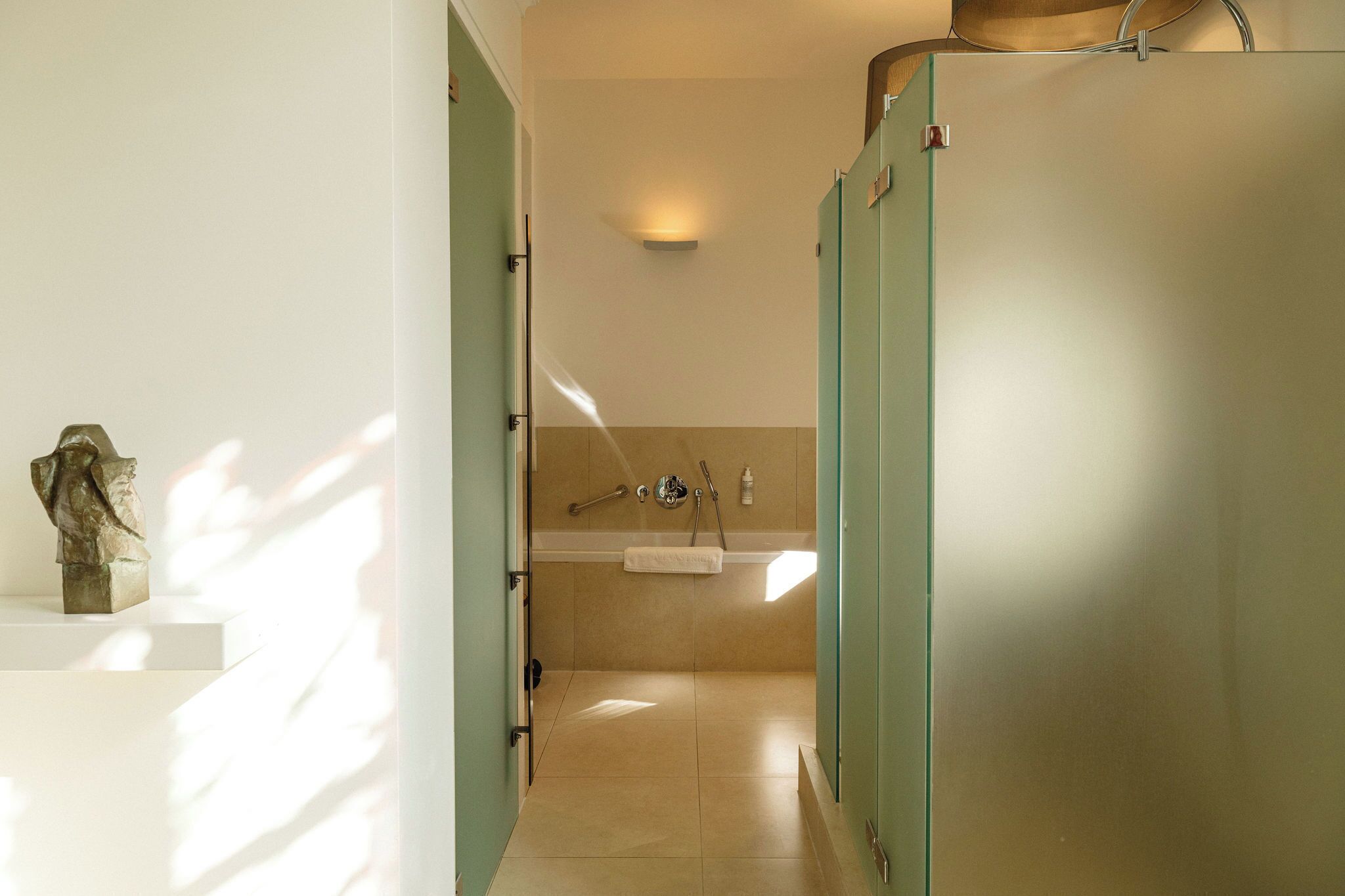 Un bagno moderno con box doccia in vetro, lavabo e porta asciugamani.