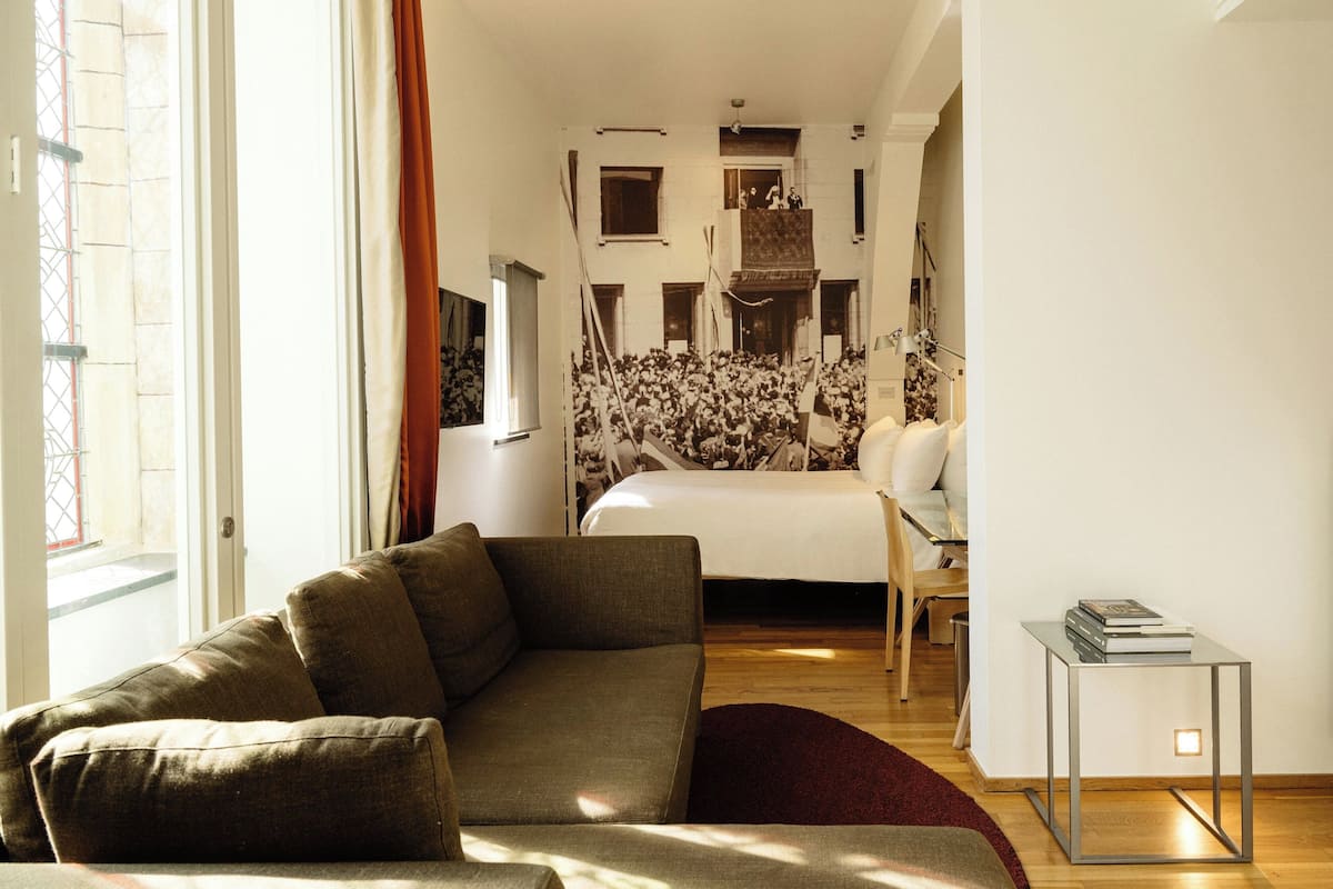 Un dormitorio moderno con una cama grande, un sofá y una mesita.