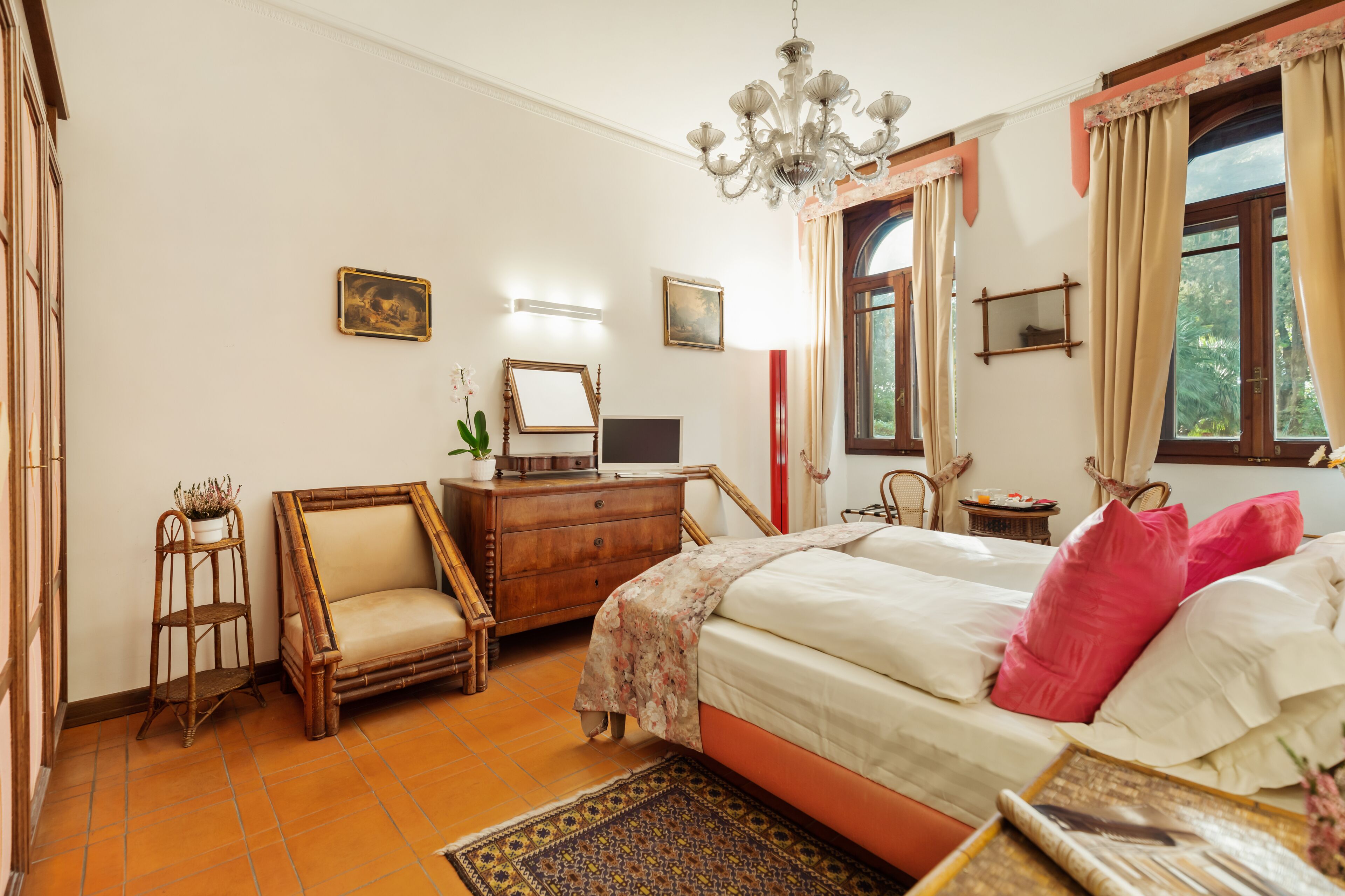 Una camera da letto con un letto, una cassettiera, una sedia e una scrivania con un computer.