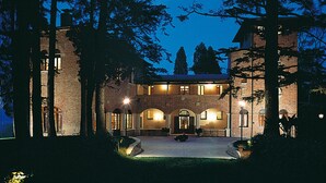 Un edificio grande su due piani, con facciata in mattoni, finestre ad arco e un ingresso centrale.