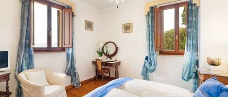 Un dormitorio con cama, una silla, un escritorio y una araña.