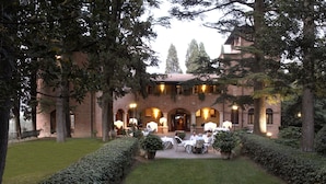 Un edificio in mattoni con un cortile interno, posti a sedere all'aperto e giardini curati.