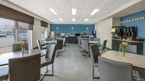A breakfast area with tables, chairs, and a kitchen counter.