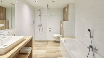 A modern bathroom with a large bathtub, a separate shower area, and a toilet.
