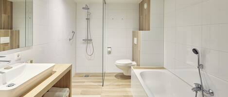 A modern bathroom with a large bathtub, a separate shower area, and a toilet.