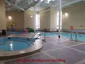 Enjoy a refreshing swim in the central pool surrounded by a walkway and a hot tub.