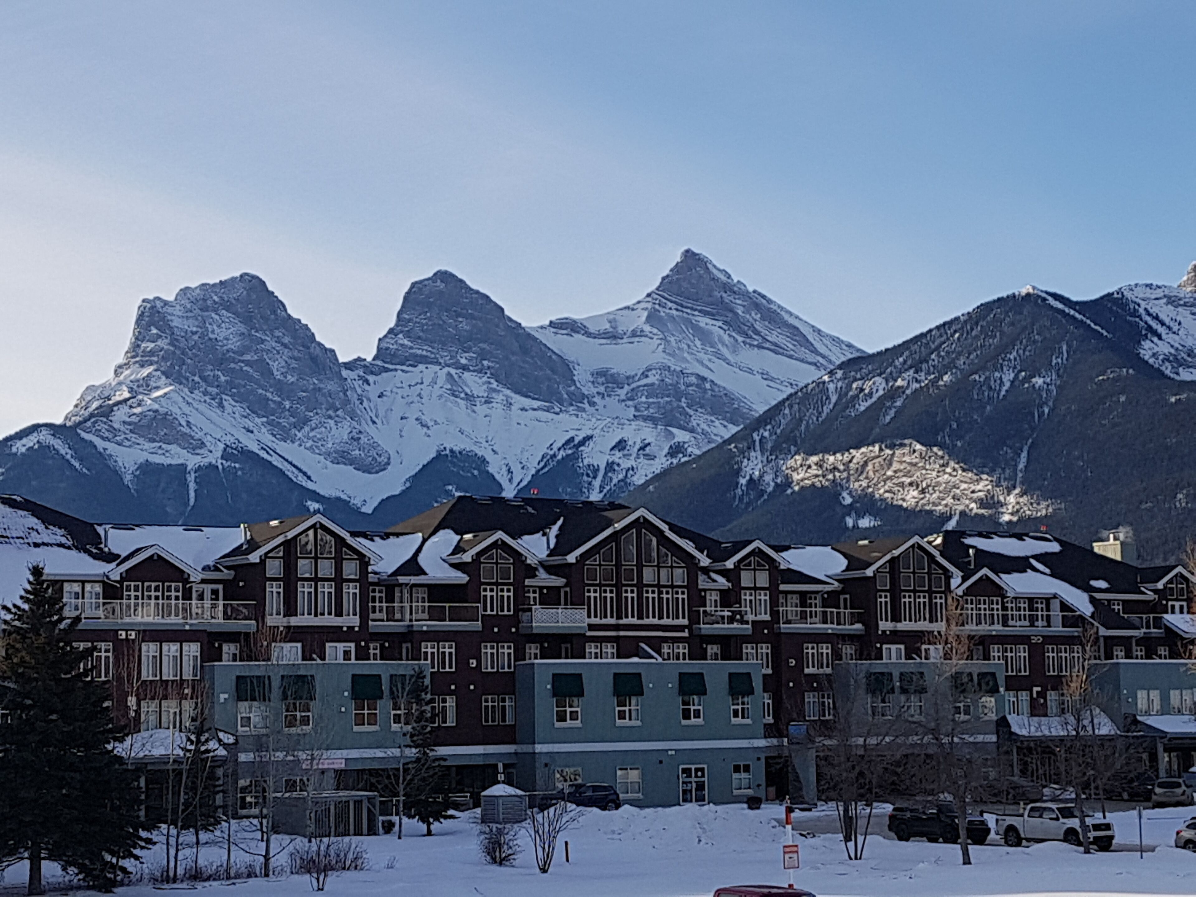A hotel with a traditional architectural style, featuring multiple stories and a prominent mountain backdrop.