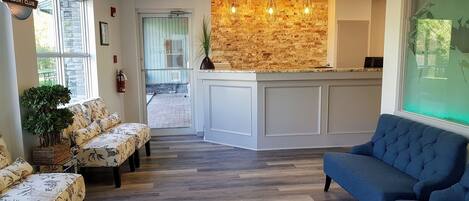 A reception area with a stone wall, a reception desk, and seating arrangements.