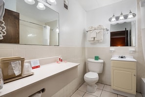A bathroom with a white sink, a toilet, a mirror, and a towel rack. - Econo Lodge Inn & Suites Windsor Locks Bradley Airport (Windsor Locks)