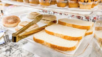 Una vitrina de panadería con muffins y pan de molde.