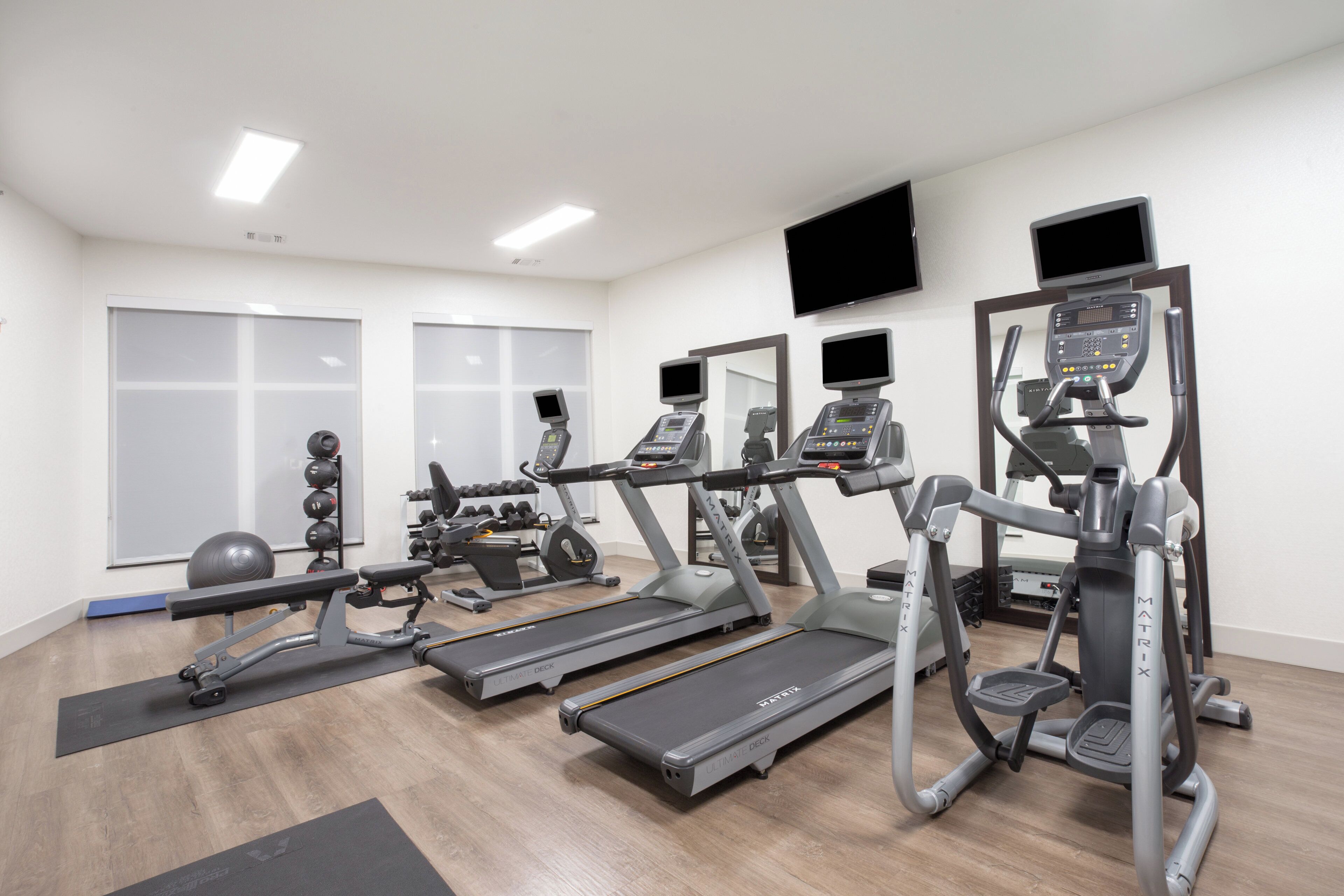 A gym with treadmills, elliptical machines, and weightlifting equipment.