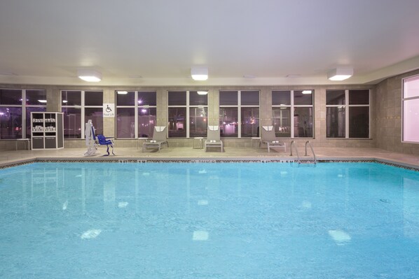 An indoor swimming pool with clear water, a pool lift, and several lounge chairs. - Holiday Inn Express & Suites Amarillo by IHG (Amarillo)