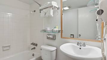 Une salle de bain équipée d’une baignoire, de toilettes, d’un lavabo et d’un sèche-cheveux.