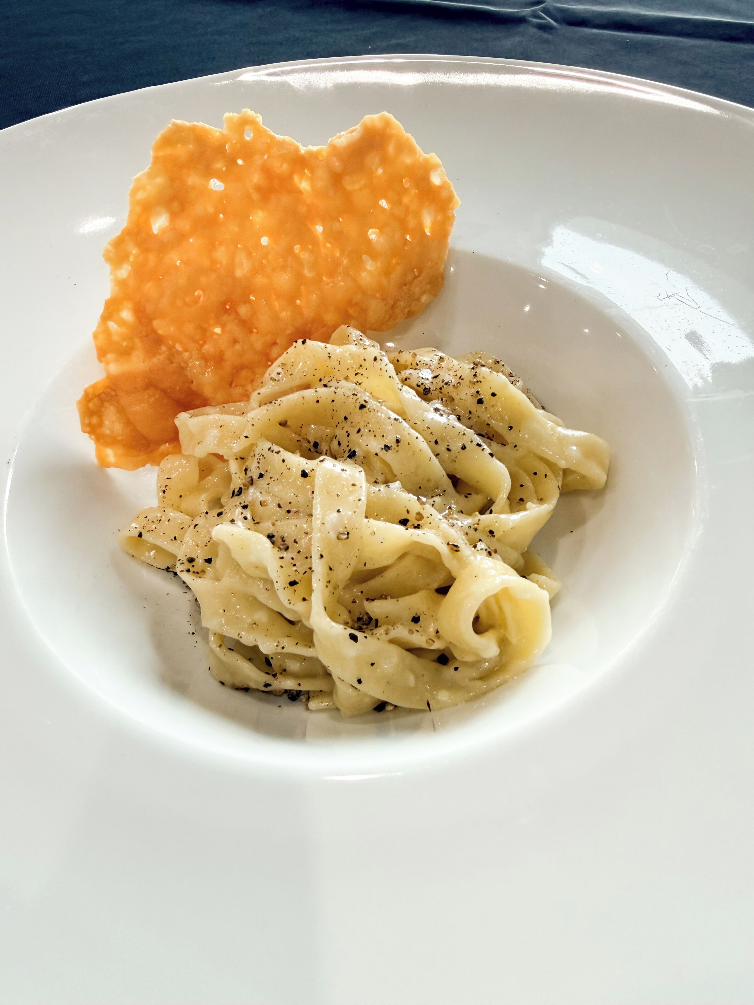 A plate with pasta and a heart-shaped cracker.
