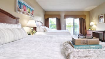 Habitación de hotel con dos camas, un ventanal grande, un cuadro y una lámpara.