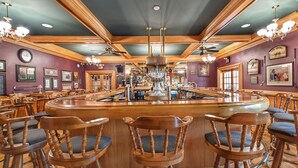 A bar area with wooden chairs, a central bar counter, and various framed pictures on the walls. - Four Seasons Island Resort (Pembine)