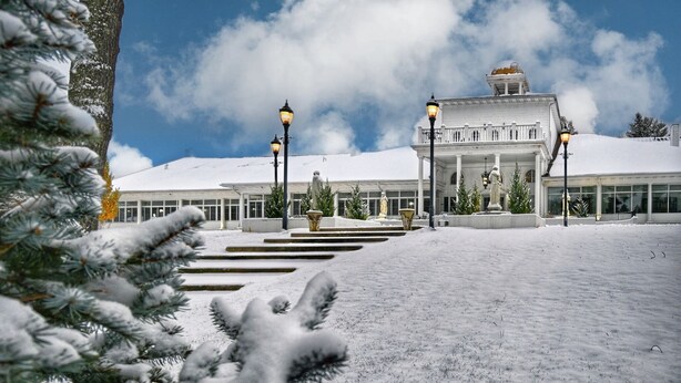 A snow-covered building with a grand entrance, steps leading up to it, and a statue in the center. - Four Seasons Island Resort (Pembine)