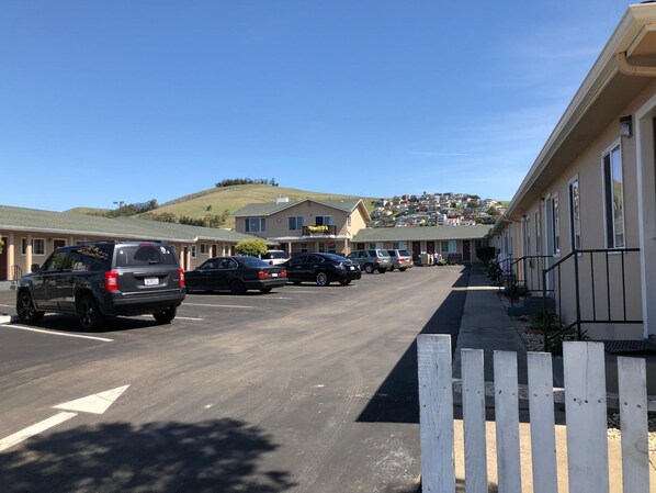 A row of single-story motels with a parking lot in front. -  SurfSide Stay Morro Bay (Morro Bay)